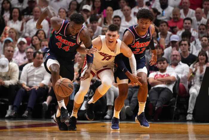 The 76ers and Heat chase a loose ball in the 2022 NBA Playoffs